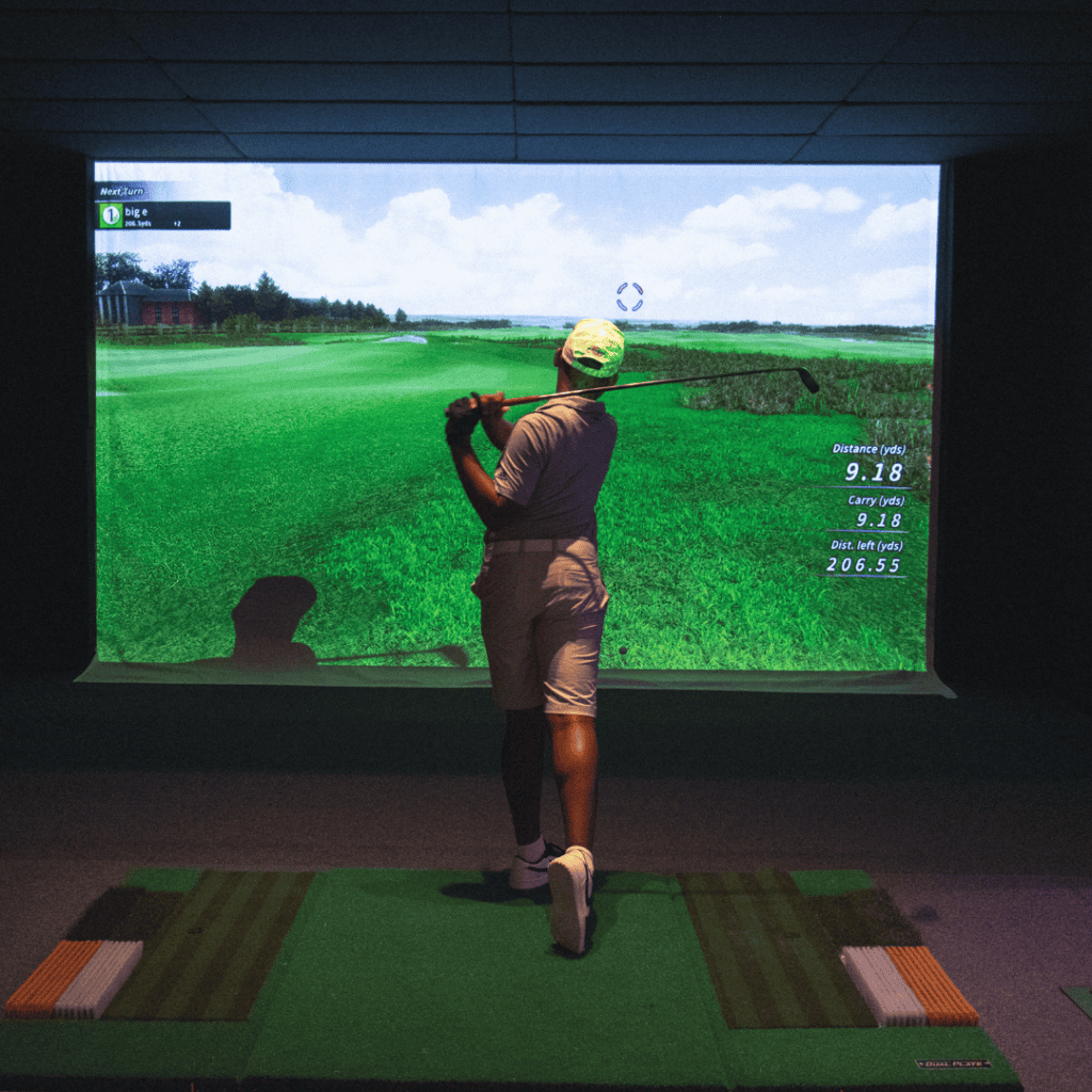 a junior golf academy student practices on a golf simulator