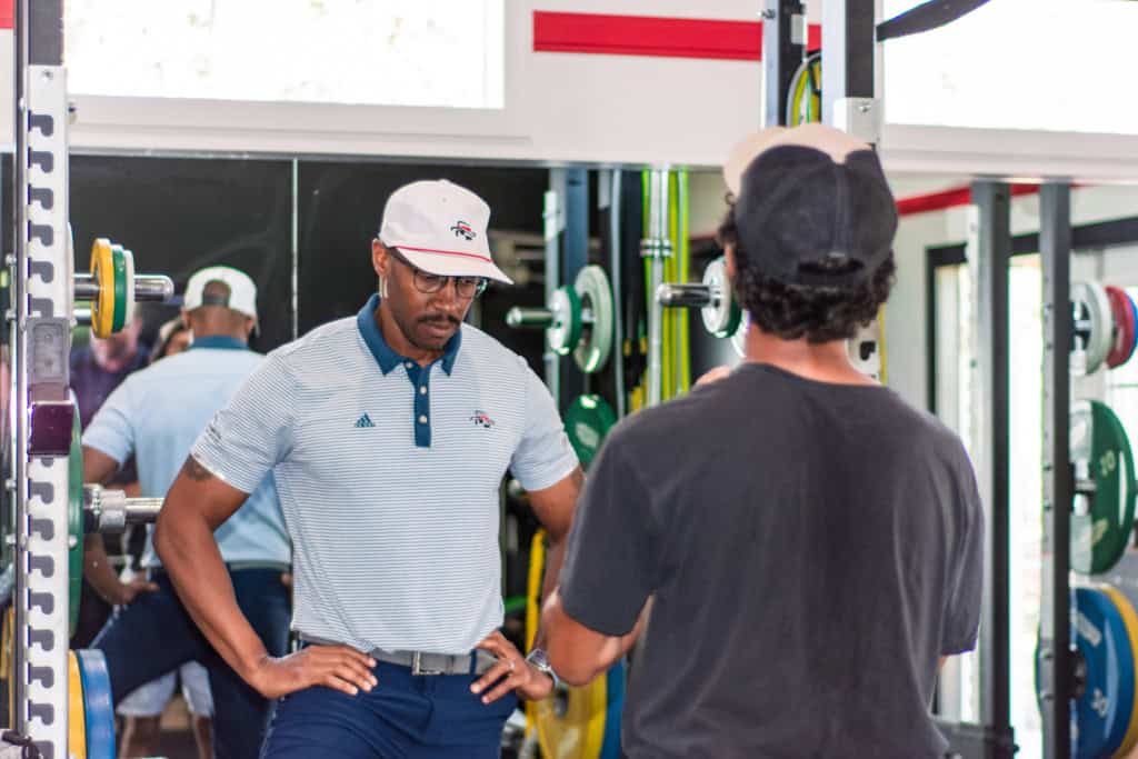 a junior golf academy student in the gym with a trainer